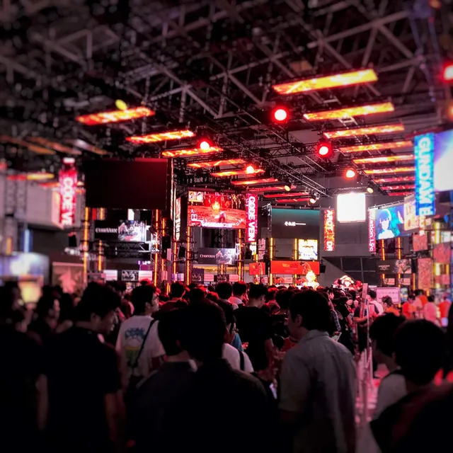赤い照明に包まれたイベント会場の人の波